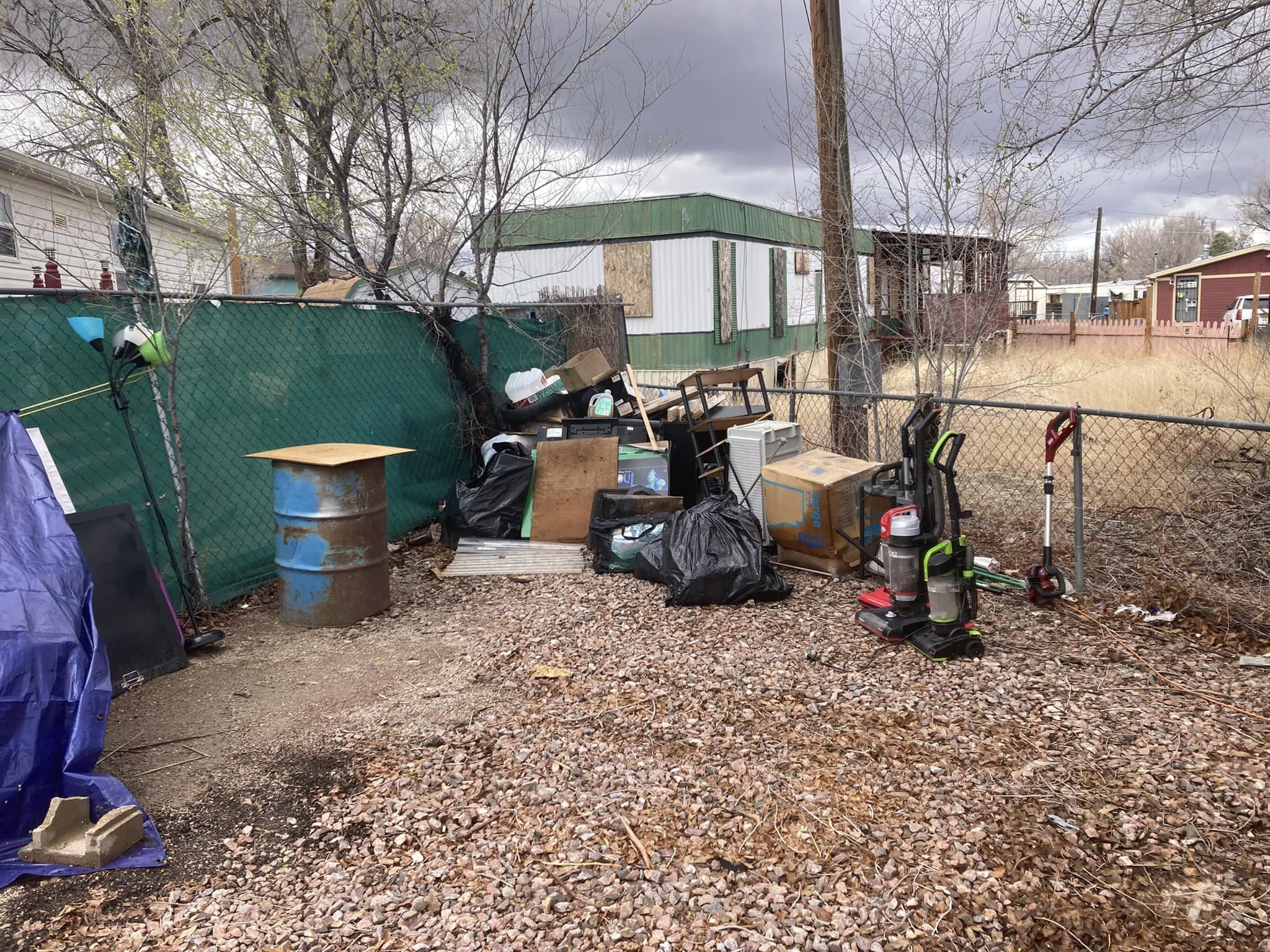 Front yard with overgrown weeds and debris before clean-up